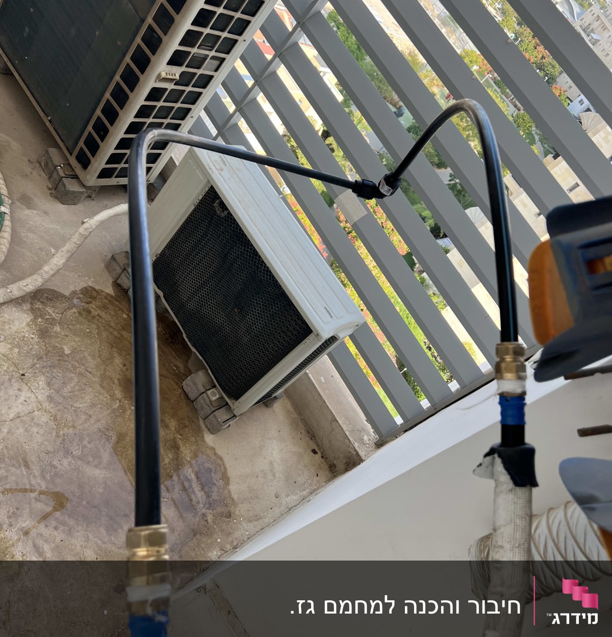 צינור שחור מחובר למערכת מיזוג אוויר על מרפסת